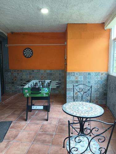 a patio with a table and a clock on the wall at Hikers Comfort in Boaventura