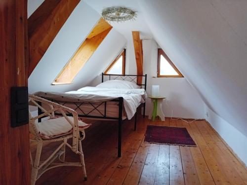 a bedroom with a bed and a chair in a attic at Gemütliche Ferienwohnung in Ranstadt in Ranstadt