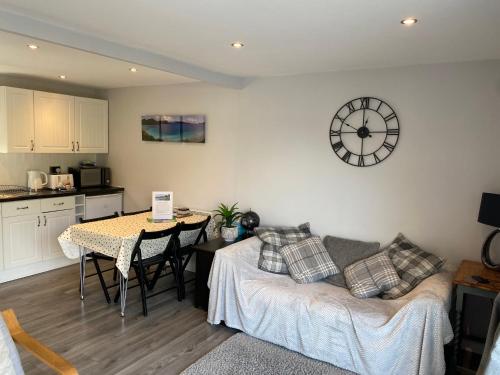 a living room with a couch and a clock on the wall at Lakeside Lodge 84 in Caeathro