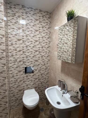 a bathroom with a toilet and a sink at Четири сезона 12 in Stoykite