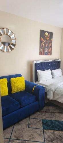 a living room with a blue couch and a bed at STADEVIEW MODERN STUDIOs in Gatunga