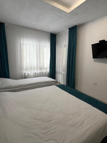a bedroom with two beds and a window at Четири сезона 12 in Stoykite