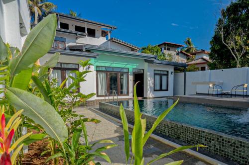 a house with a swimming pool next to a house at Villa Sanchana in Galle