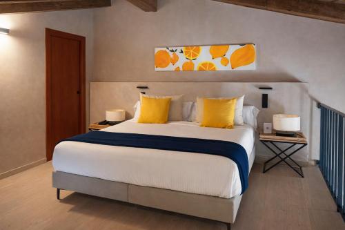 ein Schlafzimmer mit einem großen Bett und gelben Kissen in der Unterkunft Tradere Hotel Boutique in Moncada