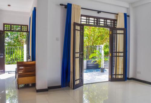 an open door with blue curtains in a room at Sea Line Villa in Galle