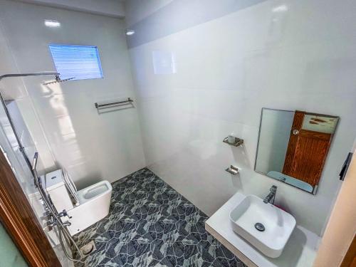 a white bathroom with a sink and a toilet at Sea Line Villa in Galle