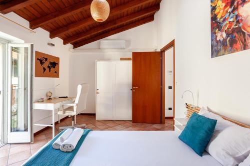 a bedroom with a large bed and a desk at Like Home XX Settembre in Sesto Calende