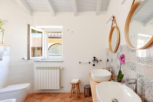 a white bathroom with a sink and a mirror at Like Home XX Settembre in Sesto Calende