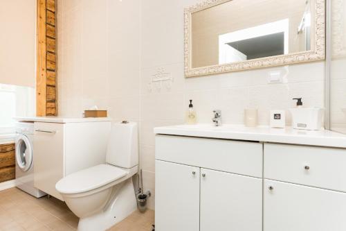 a white bathroom with a toilet and a sink at Lossiplatsi Apartment in Haapsalu