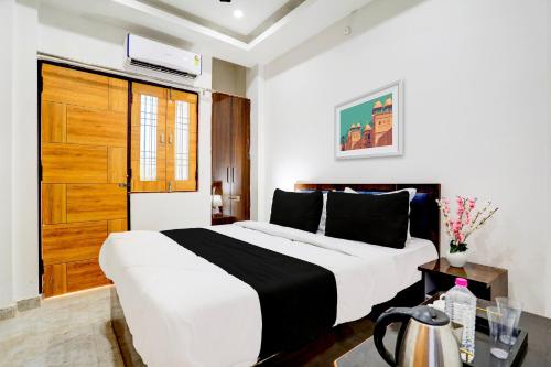 a bedroom with a large bed with a wooden door at Hotel O BGPG House in Varanasi