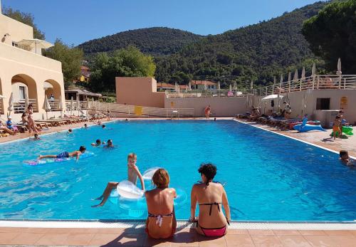 a group of people sitting in a swimming pool at Il Villaggio Di Giuele in Finale Ligure