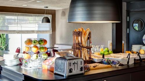 a kitchen counter with a toaster and a bunch of food at Campanile Genève - Ferney-Voltaire in Ferney-Voltaire