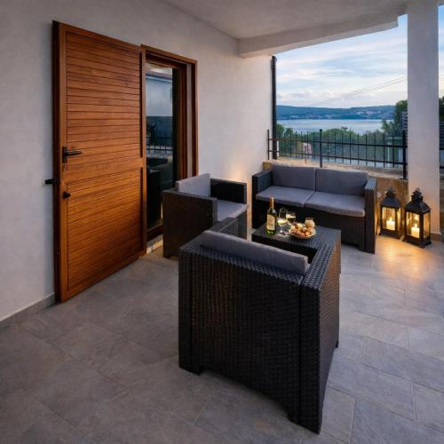 a living room with couches and a balcony at Apartma Oljka in Ankaran
