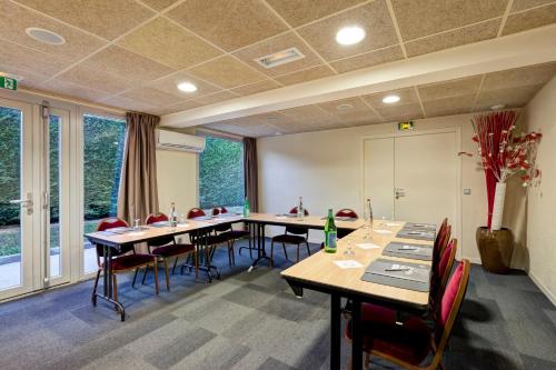a conference room with tables and chairs and windows at Campanile Genève - Ferney-Voltaire in Ferney-Voltaire