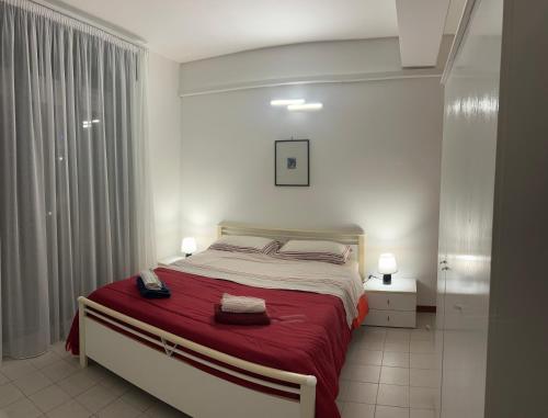 a bedroom with a large bed with a red blanket at Casa Jaya Taormina in Taormina