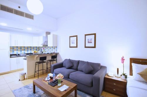 a living room with a couch and a table at Tulip Hotel Apartments in Dubai