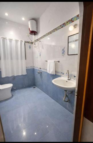 a blue and white bathroom with a sink and a toilet at Gravity Groups Blue Lagoon Villa in Kuilapayam