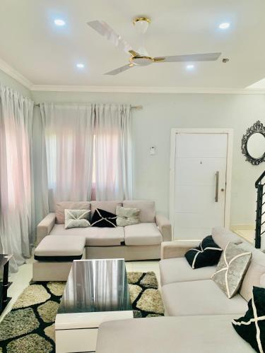 a living room with two white couches at Stylish and spacious room in a quiet environment in Dawhwenya