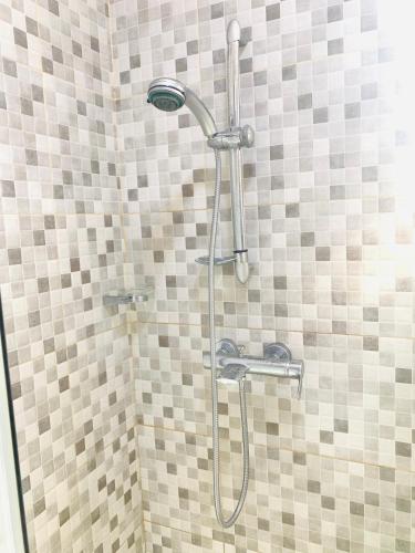a shower with a shower head in a bathroom at Stylish and spacious room in a quiet environment in Dawhwenya