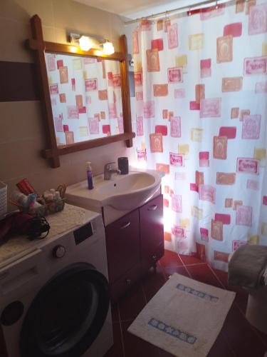 a bathroom with a washing machine and a sink at Aellia-Beautiful apartment in Vathi Samos in Vathý