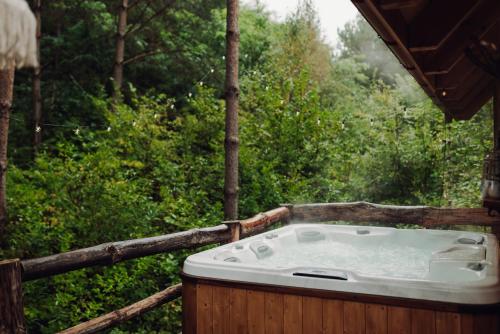 a bath tub sitting on a deck in a forest at Iglasta chata in Warszkowo