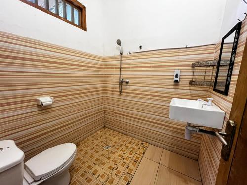 a bathroom with a toilet and a sink at Kuta Garden in Kuta Lombok