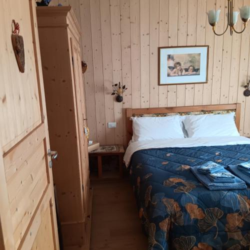 a bedroom with a bed with a blue comforter at Casa Noemi Imer in Imer