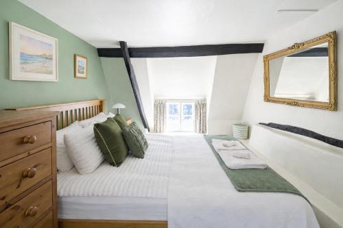 a bedroom with a large white bed with a mirror at 10 Pudding Bag Lane in Exton