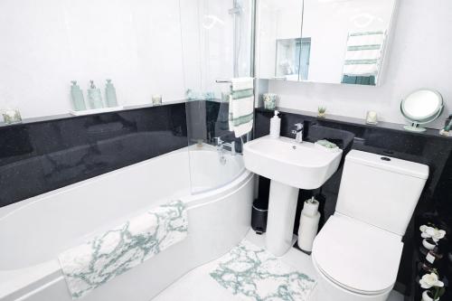 a bathroom with a sink and a toilet and a bath tub at 10 Pudding Bag Lane in Exton