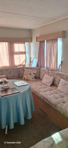 a living room with a couch and a table at Heavenly Huts GC056 in Saint Osyth