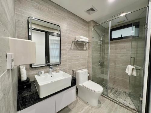a bathroom with a toilet and a sink and a shower at GEM Hotel And Residence in Hanoi