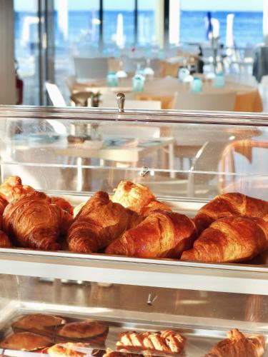 a display case with croissants and other food items at Hotel Bacino Grande in Torre Lapillo
