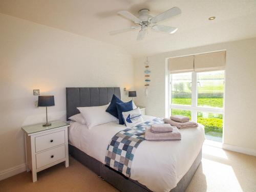 a bedroom with a bed with a ceiling fan and a window at 7 Ocean's Edge in Kingsbridge