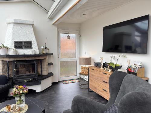a living room with a fireplace and a flat screen tv at Holiday home Max with fireplace in Thale-Friedrichsbrunn in Friedrichsbrunn