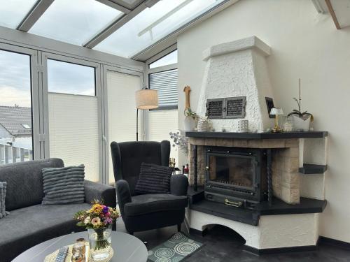 a living room with a fireplace and a couch and chairs at Holiday home Max with fireplace in Thale-Friedrichsbrunn in Friedrichsbrunn