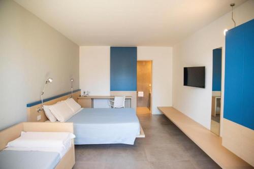 a hotel room with two beds and a tv at Hotel Bacino Grande in Torre Lapillo