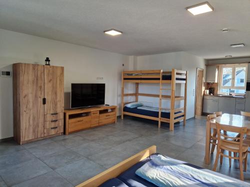 a bedroom with a bunk bed and a table and a kitchen at Gästehaus Martha in Rust