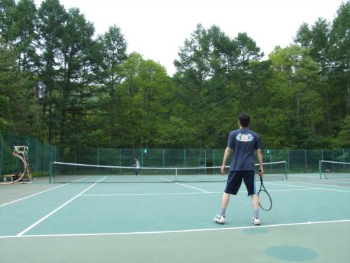 a man standing on a tennis court holding a racket at Tateshina Tokyu Hotel in Chino
