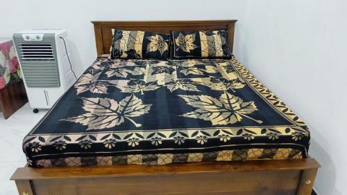 a bed with a black and white comforter and pillows at Ruk Mountain Hotel in Kengalla