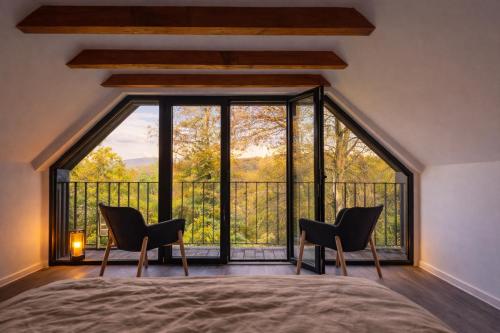 a bedroom with a large window with two chairs and a bed at KVillas in Severin na Kupi