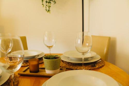 a table with wine glasses and plates on it at Modern Ground floor 2 Bed Apartment Secure Parking & Perfect for City- CelticEmirates Stadium in Glasgow