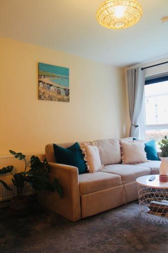 a living room with a couch and a table at Modern Ground floor 2 Bed Apartment Secure Parking & Perfect for City- CelticEmirates Stadium in Glasgow