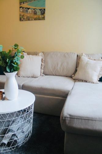 a living room with a couch and a table at Modern Ground floor 2 Bed Apartment Secure Parking & Perfect for City- CelticEmirates Stadium in Glasgow
