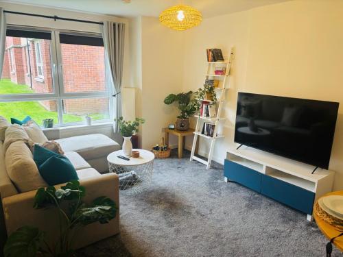 a living room with a large flat screen tv at Modern Ground floor 2 Bed Apartment Secure Parking & Perfect for City- CelticEmirates Stadium in Glasgow