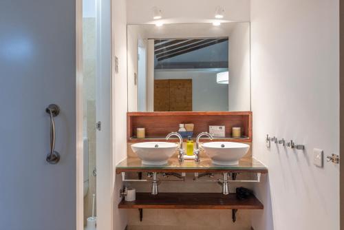 a bathroom with two sinks and a mirror at Casa Arizo, Hotel Boutique & Bike Friendly in Oropesa del Mar