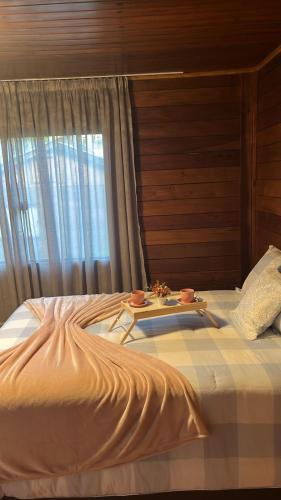 a bed with a tray of food on top of it at Chalé Garden - Pedra Azul in Domingos Martins