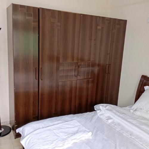 una camera da letto con un mobile in legno accanto al letto di Apartment 5 area ad Aqaba