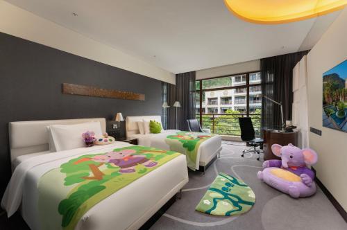 a bedroom with two beds with stuffed animals on it at Le Méridien Xiamen in Xiamen