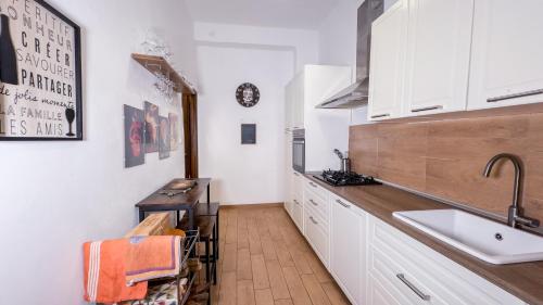 a kitchen with white cabinets and a sink at Veranda Liberty, luxury apartment in La Spezia
