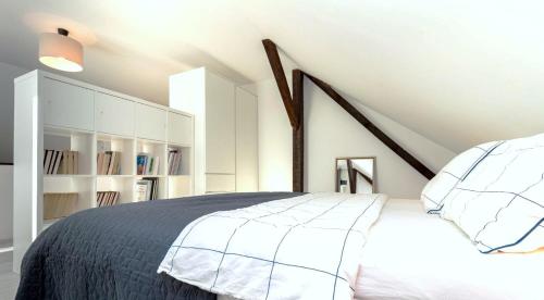a bedroom with a white bed and an attic at Chic Palace - Boutique studio apartment in Vukovar